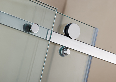 Close-up of stainless steel roller wheels on the top track of a clear glass sliding shower door
