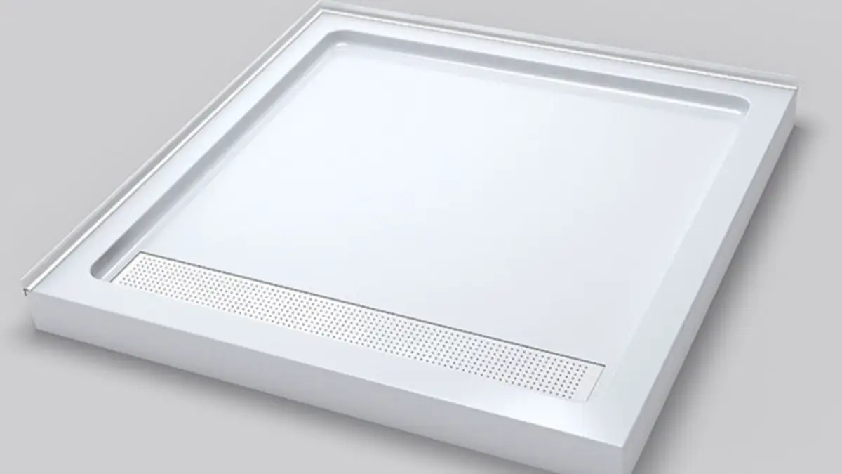 White rectangular low-profile shower tray with linear drain grate and raised rim, product photo on gray background