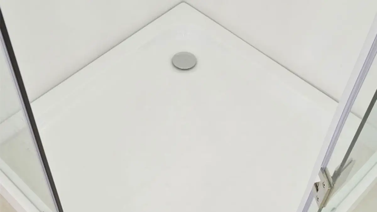 White low-profile shower base with chrome center drain inside frameless glass enclosure